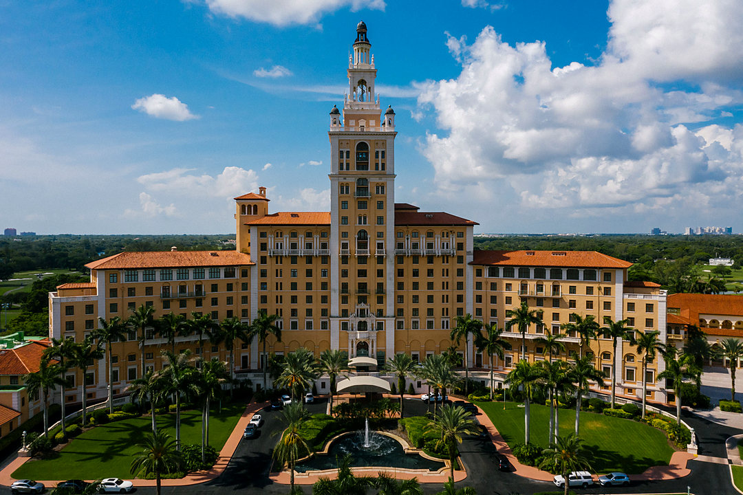 Aerial view of a landmark tower surrounded by palms in Boca Raton